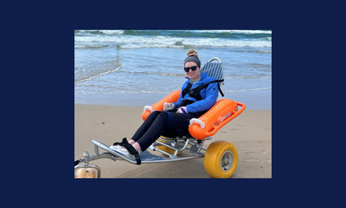 Girl sitting in beach wheelchair