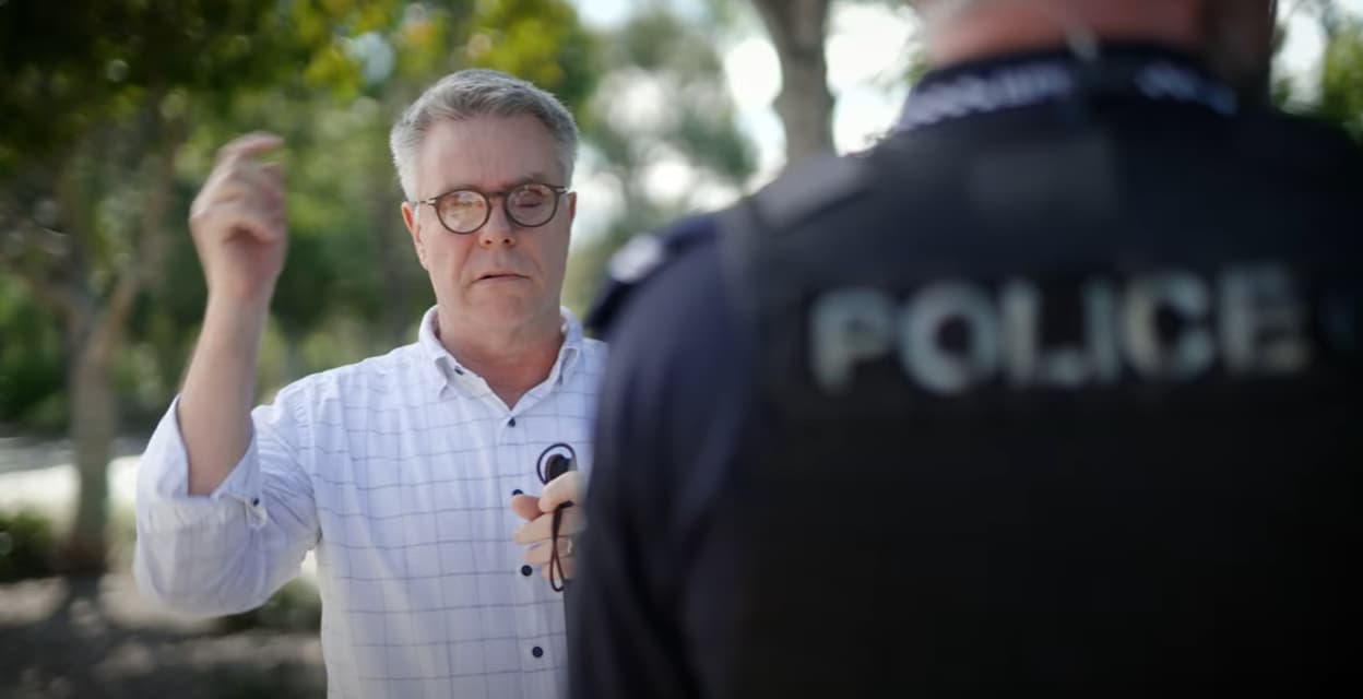 Man talking to police officer.