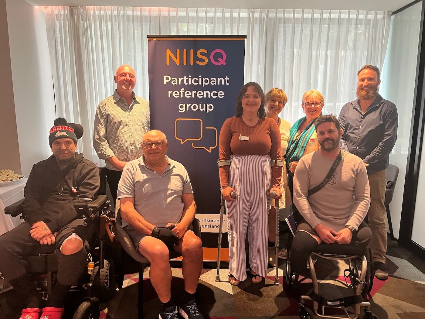 Image of adults standing in front of a sign called Participant Reference Group